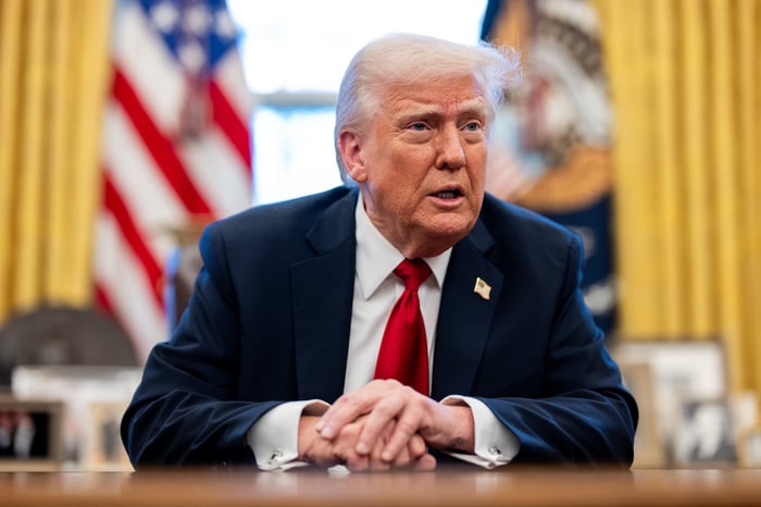 President Donald Trump sitting at the resolute desk in the Oval Office.