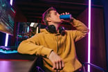 Person drinking a can of energy drink and gaming