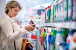 choosing domestic cleaning product by the supermarket shelf