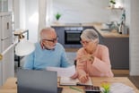 Senior couple at a desk serious GettyImages-1399367653