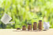25_02_06 A water pail watering plants atop a rising series of coin piles leading to a piggy bank_ MF DloadGettyImages-1236903031-1200x800-5b2df79