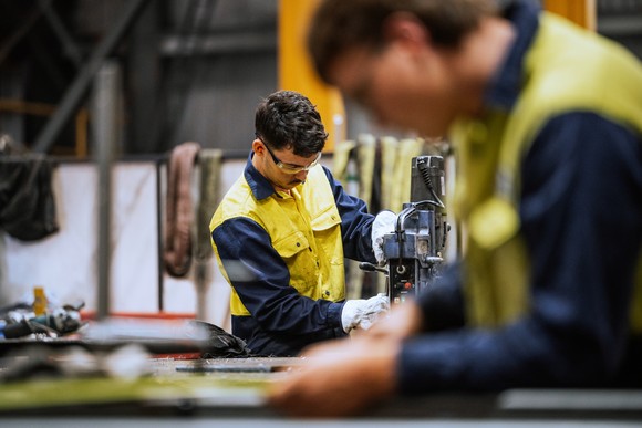 People working on an industrial line in a manufacturing plant.