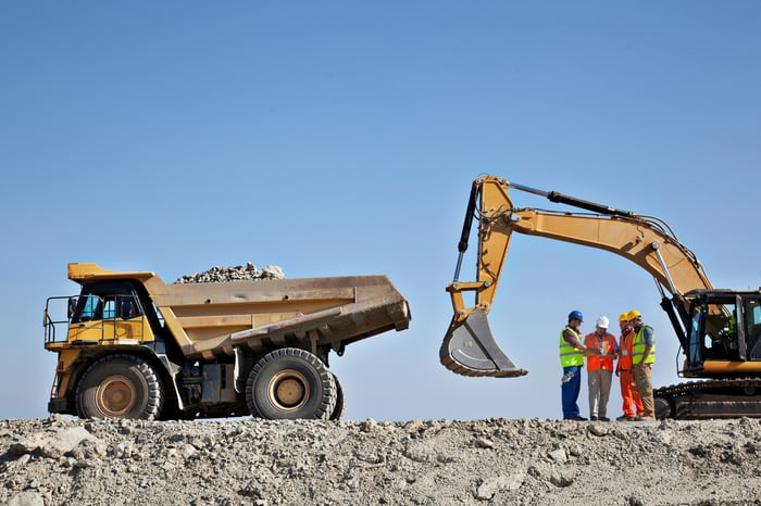 A dump truck being loaded with materials.