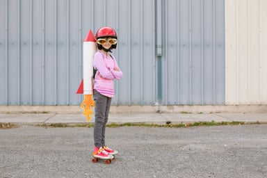 Girl on roller skates with a toy rocket behind them.