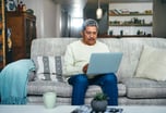 senior man laptop couch GettyImages-1357522262