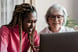 Young person and older person gazing at a laptop screen