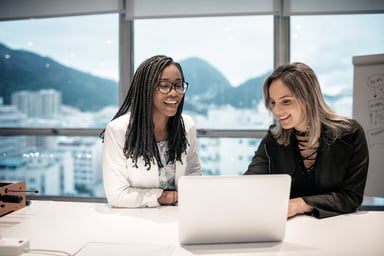 two business people collaborate in an office with the mountains of Rio de Janeiro in the background