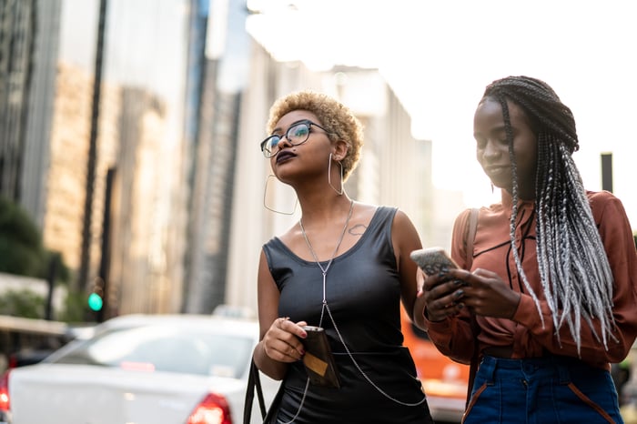Two passengers hail a ride with a mobile app.