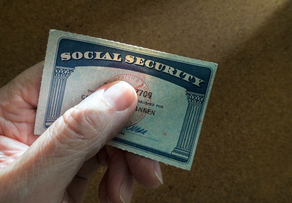 A hand holding a Social Security card.