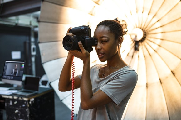 A photographer at work in front of a lighting rig.
