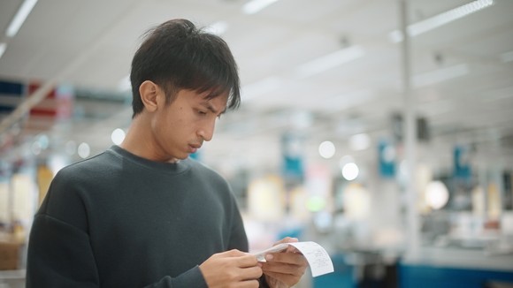 Someone looking at a receipt in the store.