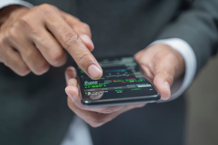 A person buying a stock using a smartphone.
