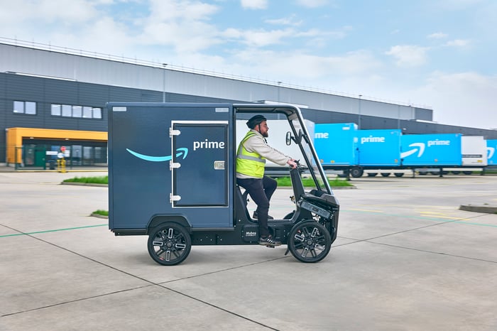 A worker drives an Amazon electric delivery bike.