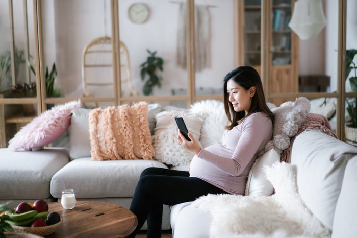 Person sitting on a couch with a phone.