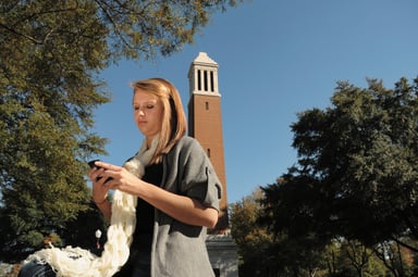 student looking at phone at University of Alabama-1201x797-bfe2eb8