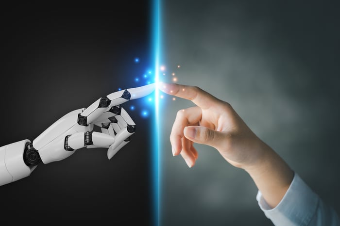 A human finger touches the finger of a robotic hand.