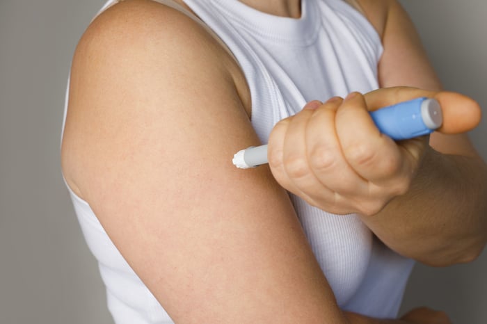 A person self-administering a weight loss drug subcutaneously.