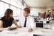 young professional woman and man speaking laughing in office