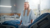 Patient sitting on hospital bed.