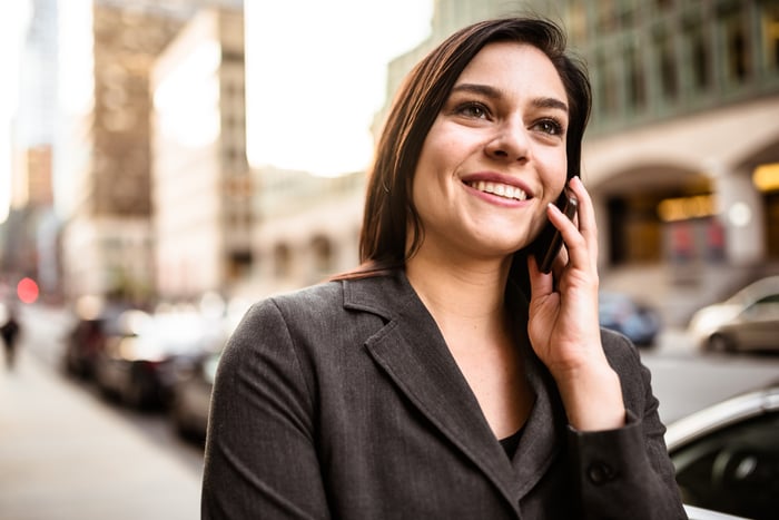 Person on city street, talking on phone.