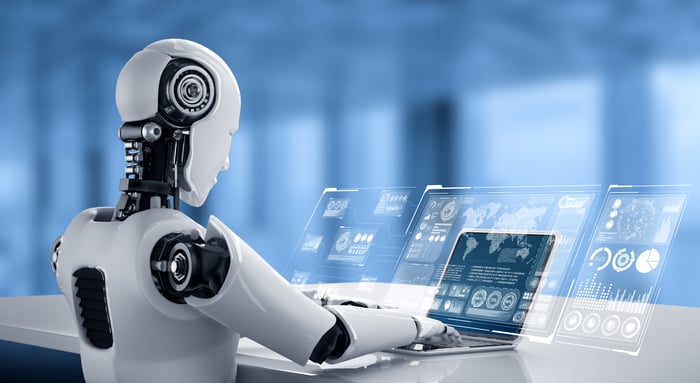 A humanoid robot working at a computer.