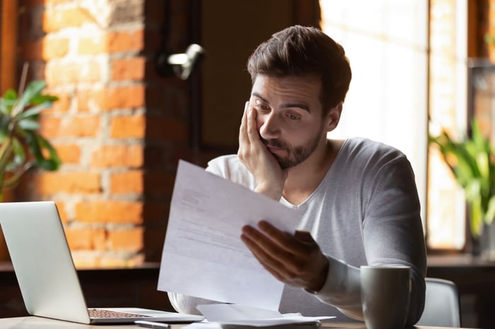 Concerned person looking at a piece of paper.
