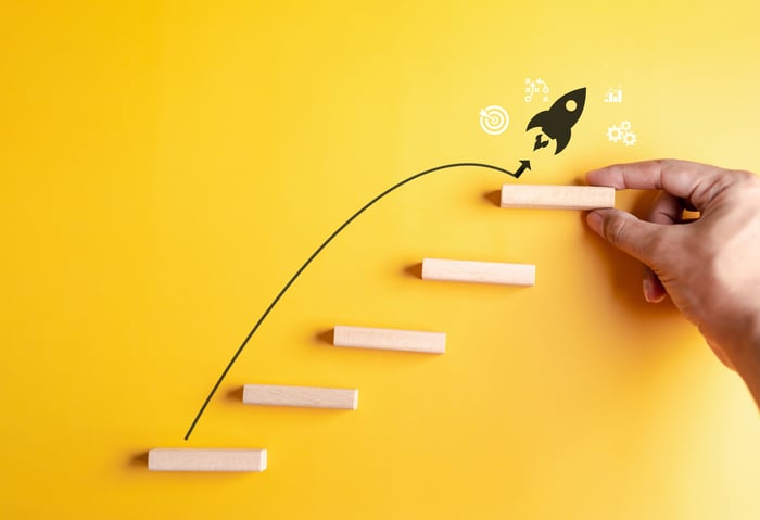 A black cartoon rocket jumping upwards in front of a yellow background.