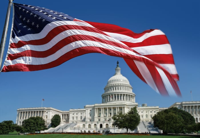 American flag in foreground, Capitol Building in background.