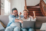 investors celebrate looking at laptop.