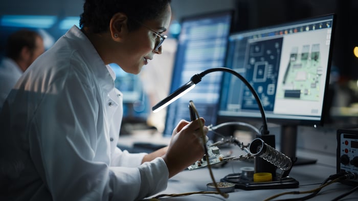 Person looking at a computer chip in a factory.