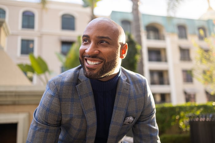 Smiling person in checkered suit.