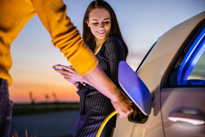 Driver charging electric car.