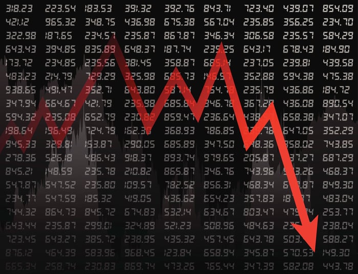 Red down arrow on a black backdrop of ticker tape prices.