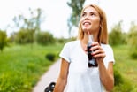 Person drinking bottled drink with a straw