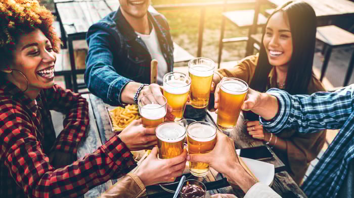 A group of friends drink beer together in a fast-casual restaurant.