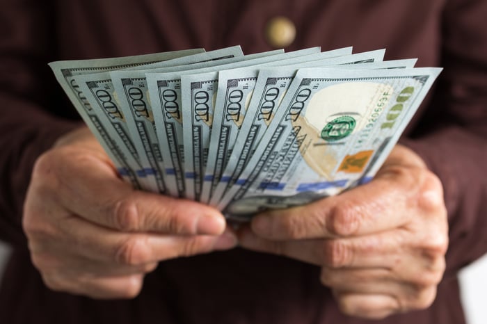 A person holding lots of cash.