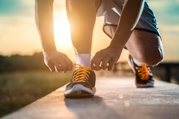 Two hands lacing up sneakers.