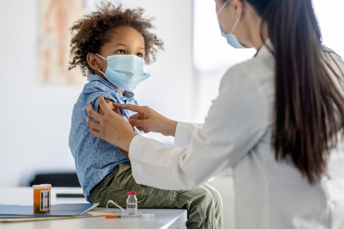 Child receiving a vaccination shot from a healthcare professional.