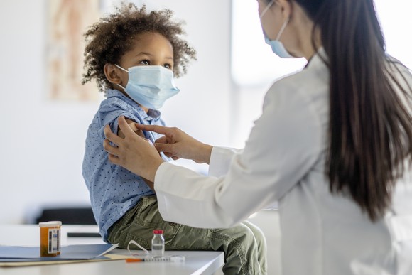 Child receiving a vaccination shot from a healthcare professional.