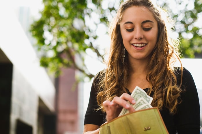 A person taking money out of a wallet.