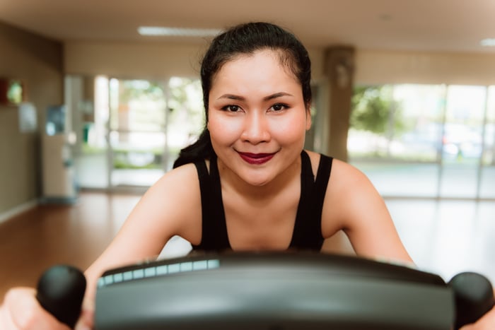 A person smiling on an exercise bike. 