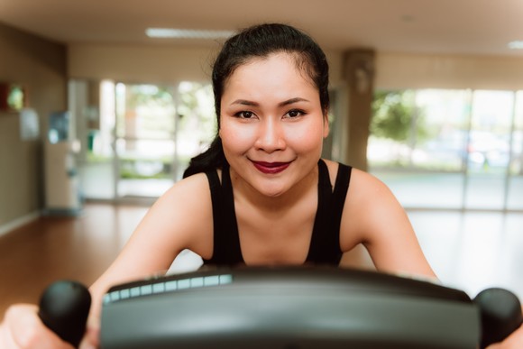 A person smiling on an exercise bike.