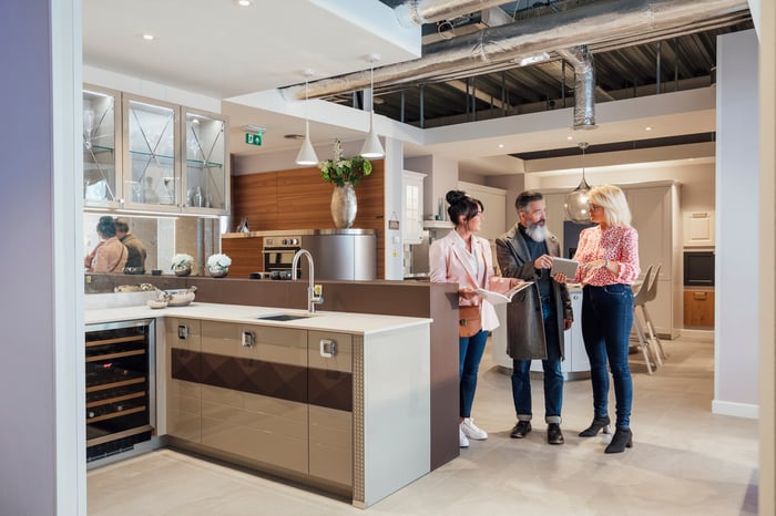 People looking at kitchen setup in a home improvement store.