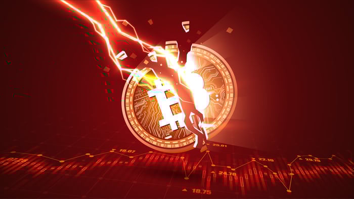 A coin with the Bitcoin logo is struck by lightning and split into two.