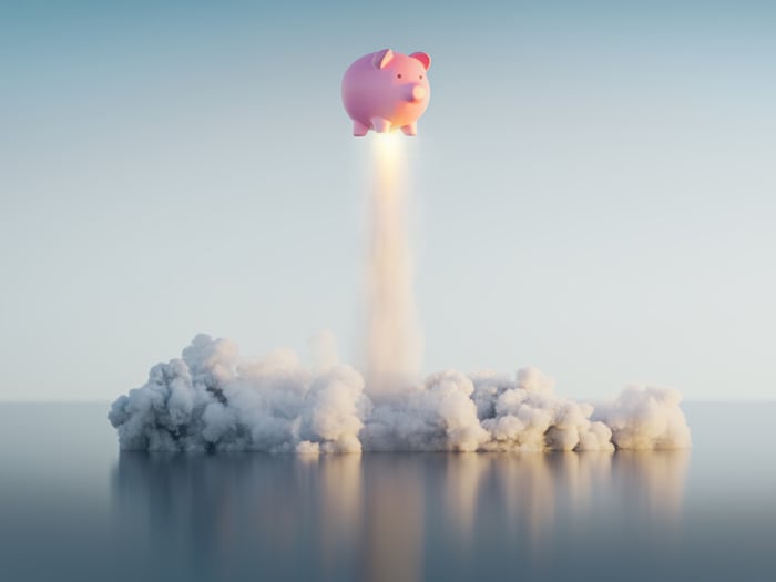 A pink piggy bank rocketing into the sky.