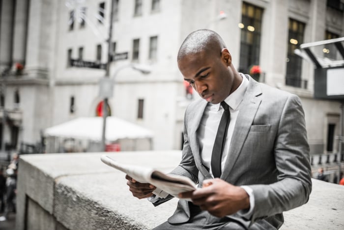 An investor reads a newspaper.