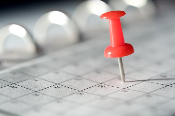 A pin marking a date on a calendar. 