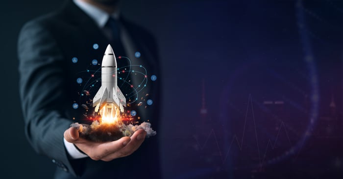 A man holds a rocket ship animation in his hand.
