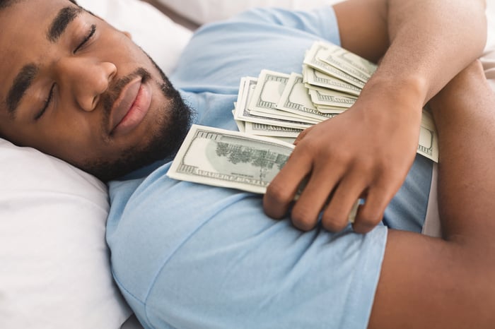 A person sleeping while clutching cash.