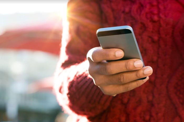 A hand holds a smartphone.